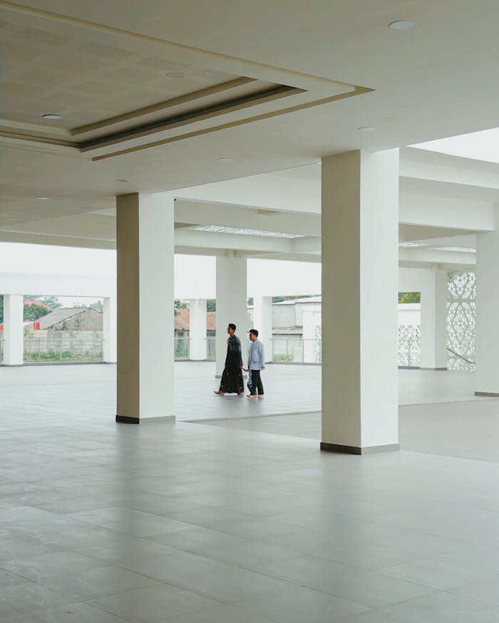 Spacious interior with people walking in a modern mosque in Indonesia.